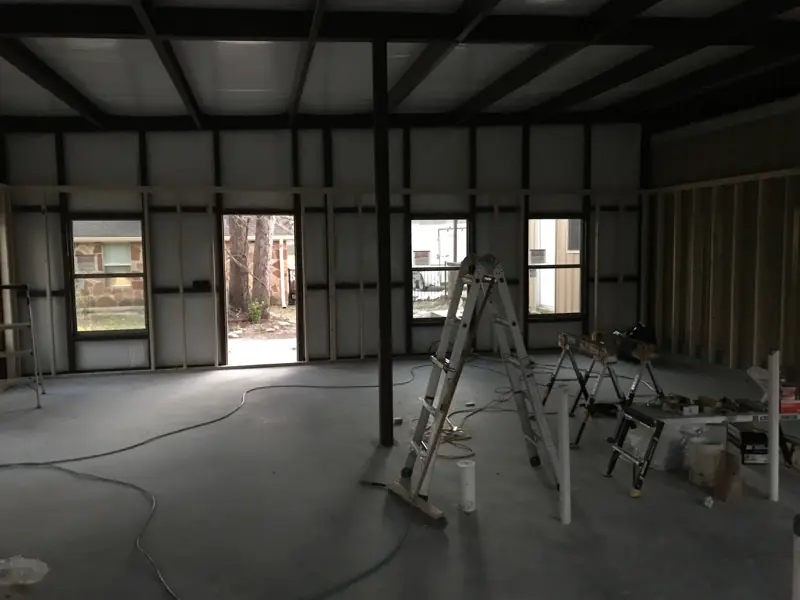 Interior of the metal building with windows and a door in, ready for the interior walls.