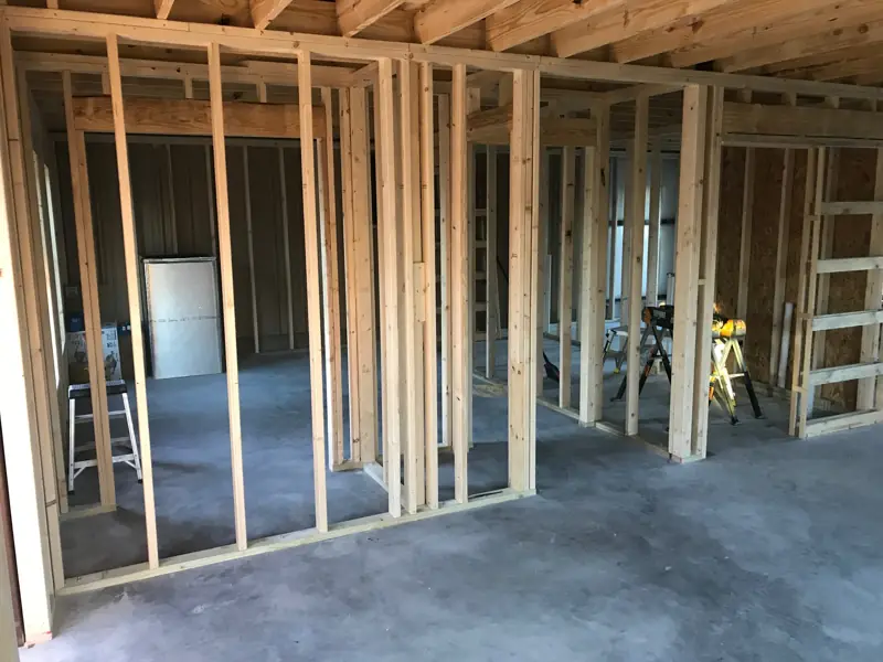 Rooms framed in wood under ceiling joists inside the metal building.