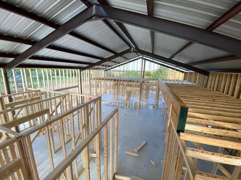Interior walls and loft joists framed inside the building.