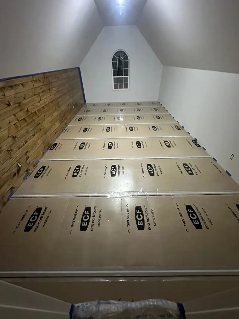 Cork-foam underlayment panels laid across the bonus room floor.