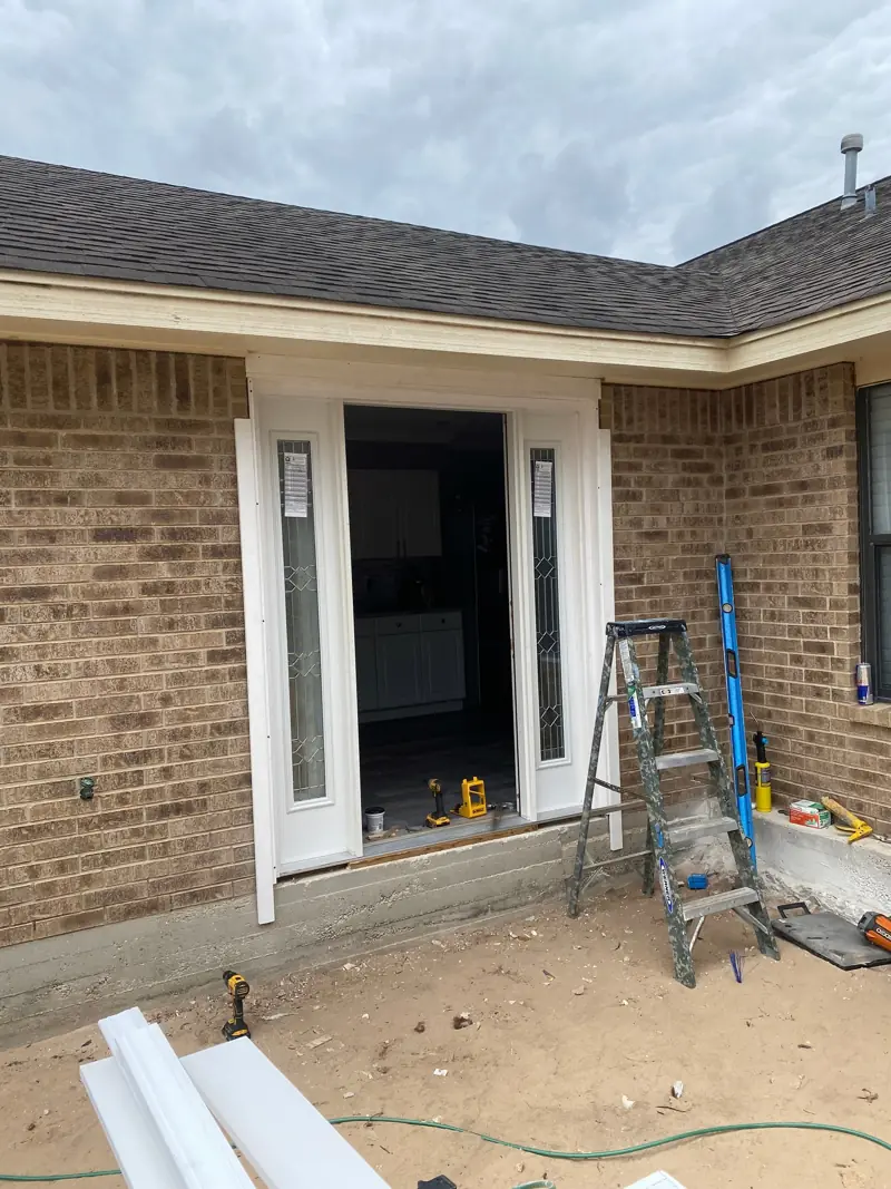 Front door opening framed for sidelights in a brick wall.