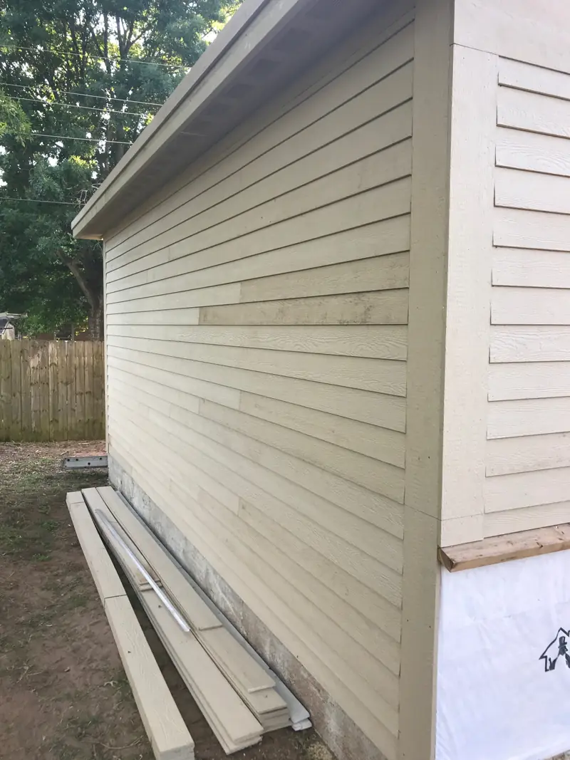 Side wall of the garage finished in lap siding with trim at the corner.