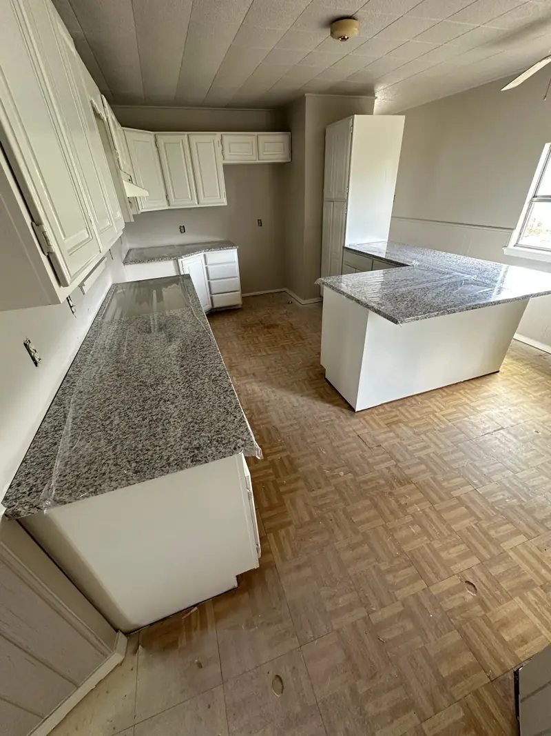 Kitchen with white painted cabinets and new granite countertops.