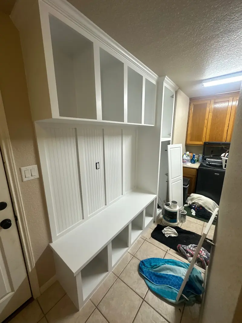 The mudroom bench and lockers painted white, with cubbies under the bench.