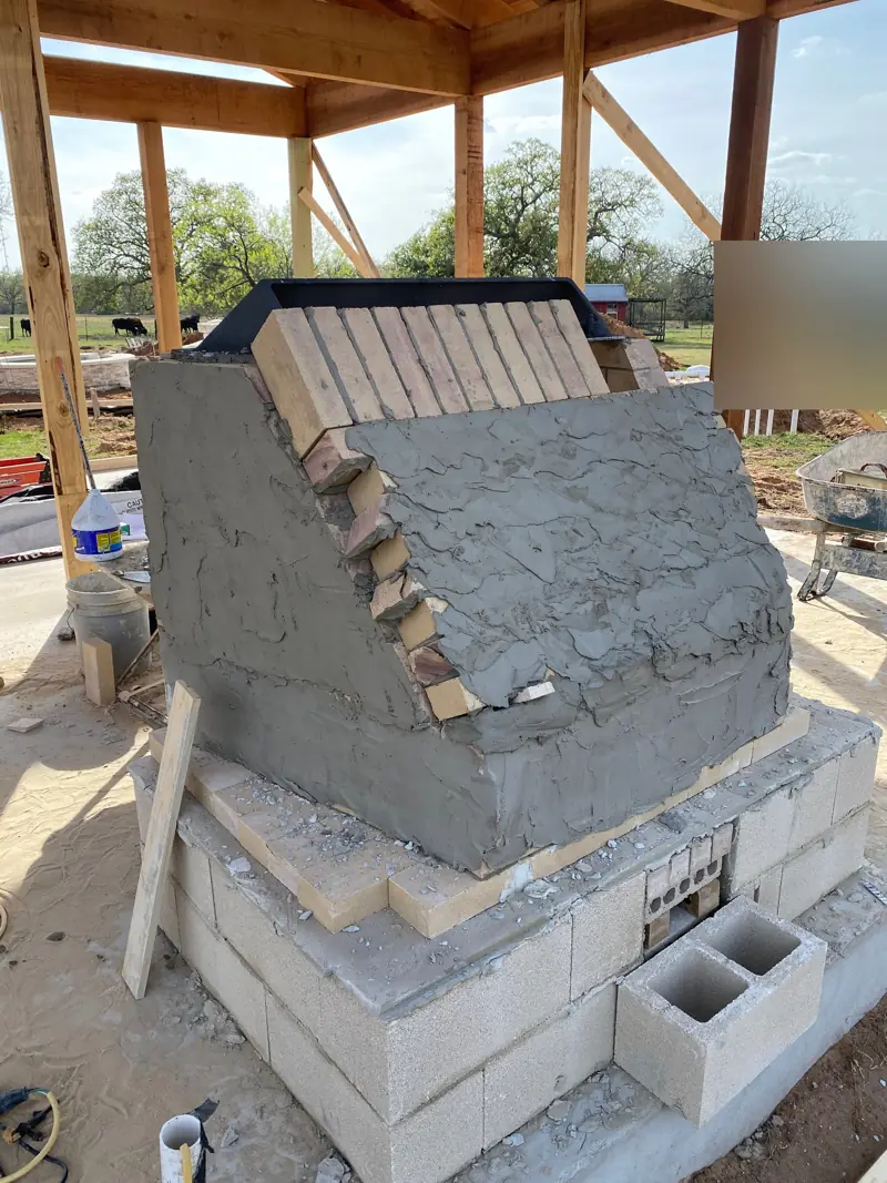 Firebrick smoke chamber parged over on a block base.