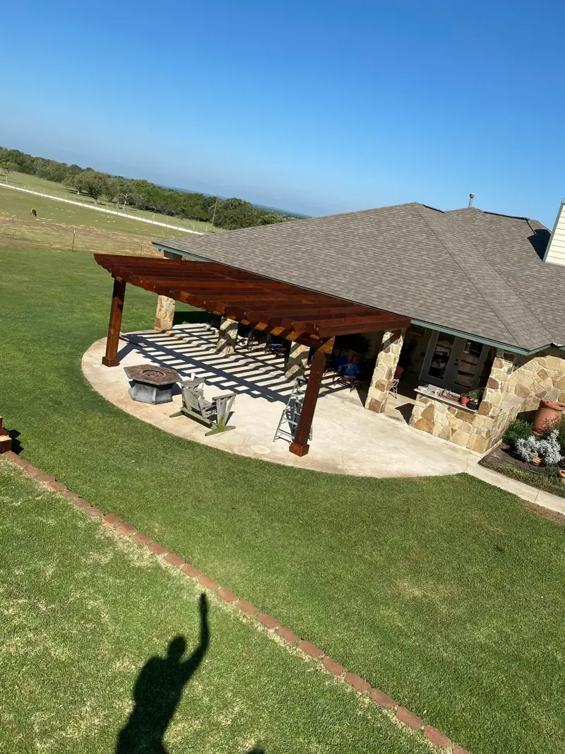 The pergola over a round patio with a fire pit, seen from above.