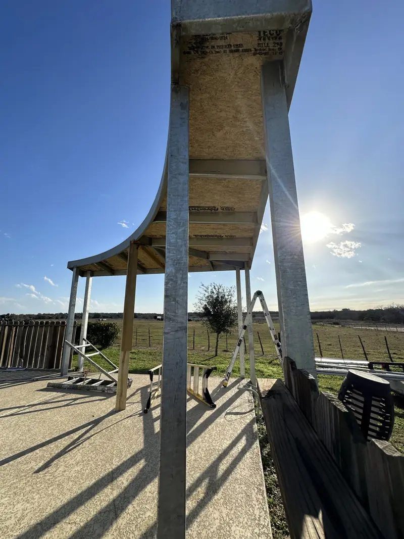 Looking up at the curved beam of the pool cover frame.