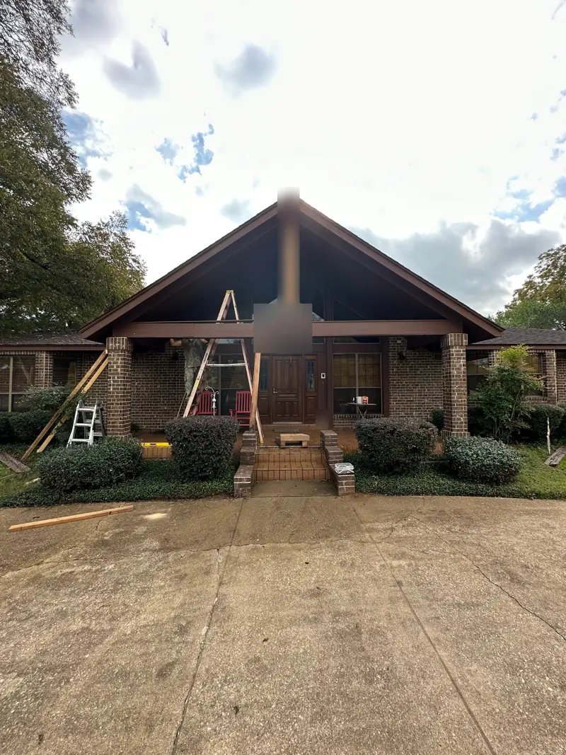 Brick house with a gable porch, ladders up to the beam.