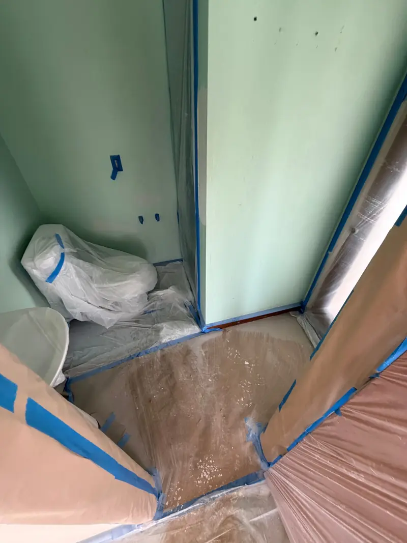 Bathroom masked off, the toilet wrapped in plastic.
