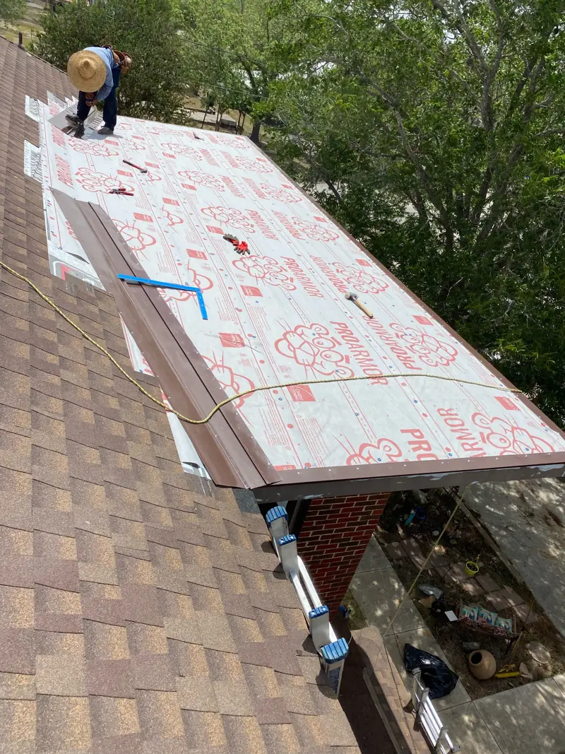 Underlayment on the repaired section, a roofer at the top.