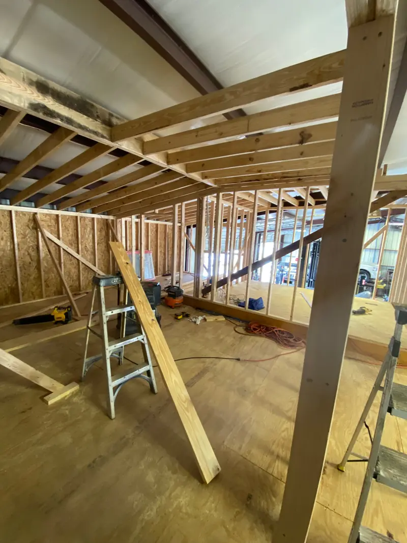 Upstairs floor and ceiling joists framed inside a shop.