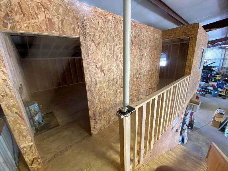 Sheathed rooms upstairs with a stair rail, the shop below.