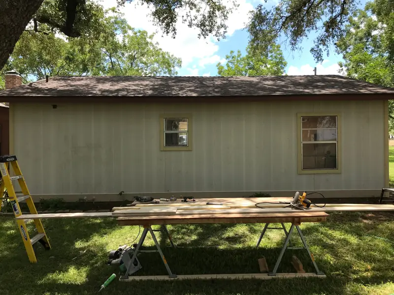 The same wall in new pale vertical panel siding around the windows.